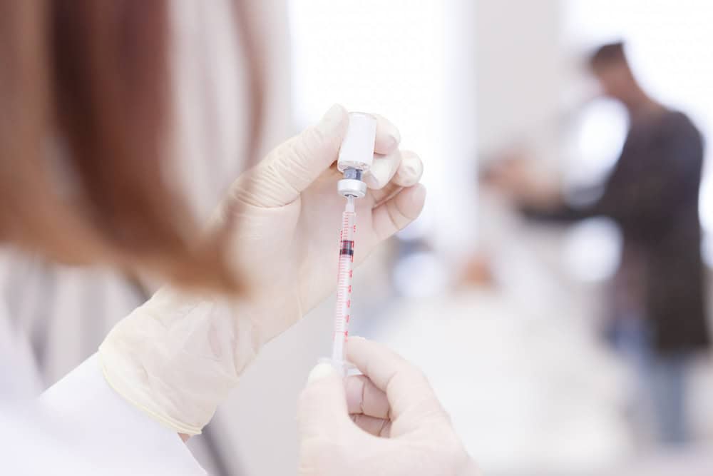 A doctor preparing an injection syringe