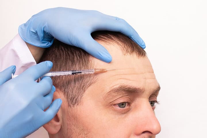 A cosmetologist injects Botox into a man