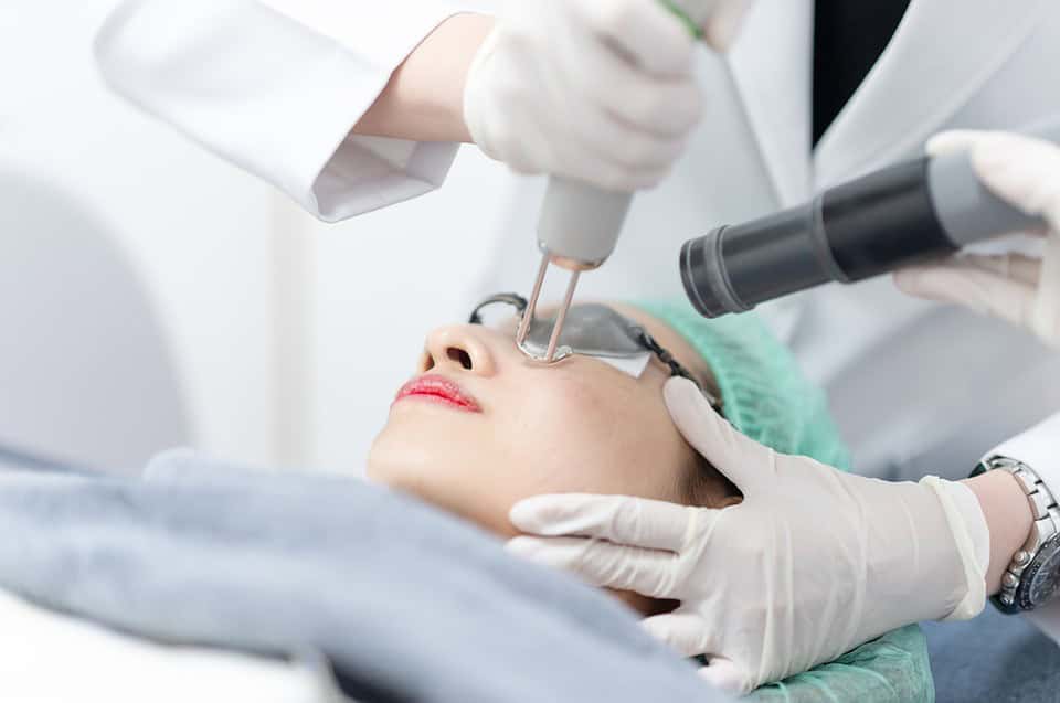 A woman receiving a pico laser facial treatment at a clinic