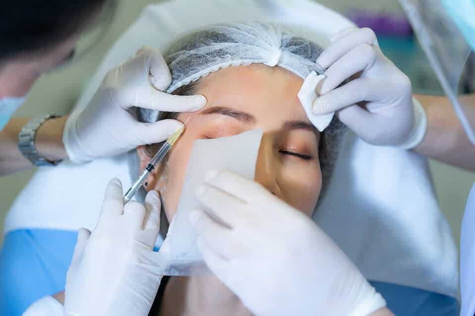 A woman getting temple filler injections