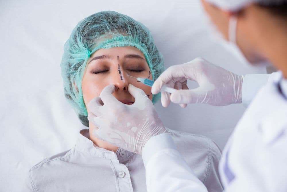 A woman prepares to undergo rhinoplasty surgery