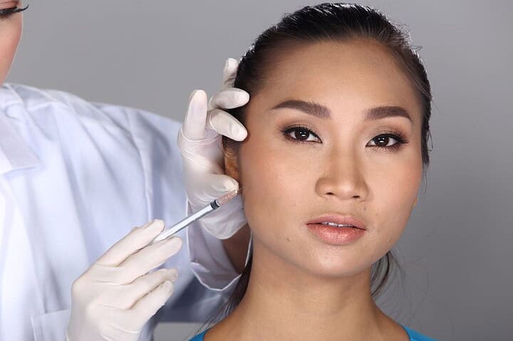 A woman has a cheek filler treatment in Bangkok