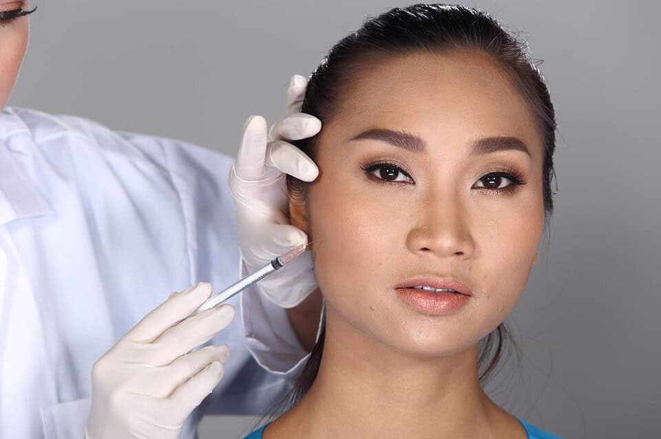 A woman has a cheek filler treatment in Bangkok