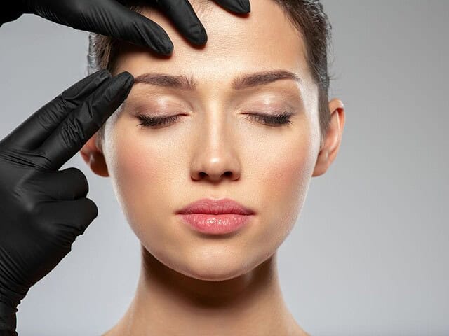 An aesthetician checking a patient’s face before HArmonyCa