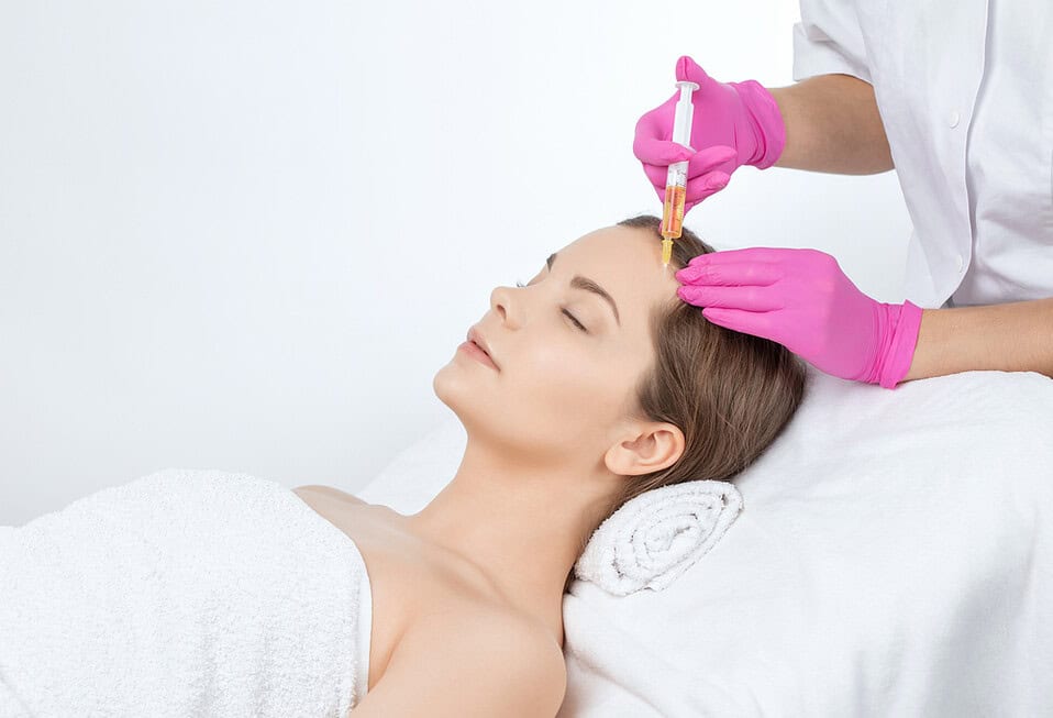 A woman undergoing PRP hair treatment, which begs the question: how long does it last?