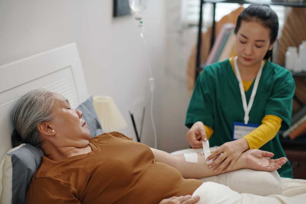 older asian woman receives treatment for fat loss via IV