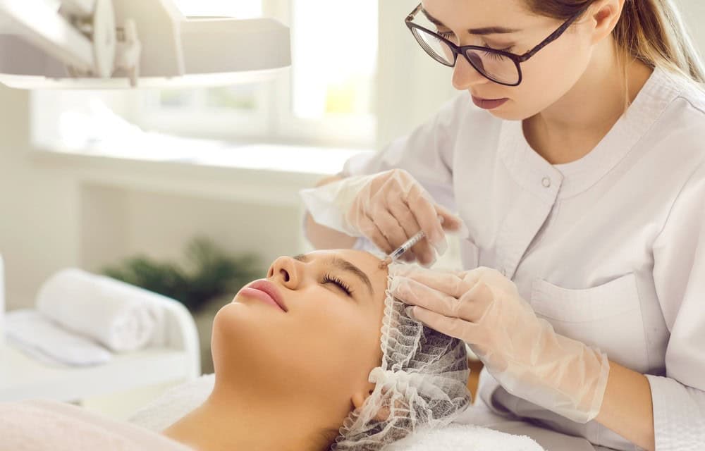 oung asian woman prepares to receive a facial injection from a female doctor