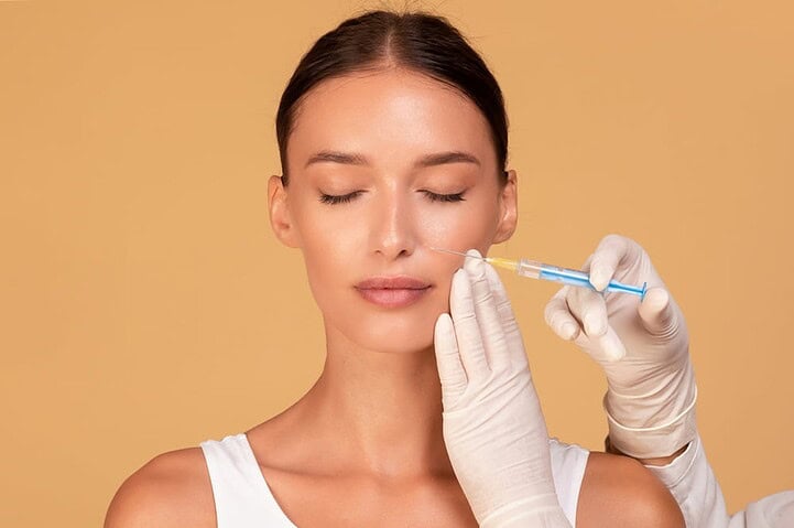 A Caucasian woman receiving a nasolabial fold filler from an aesthetic doctor.