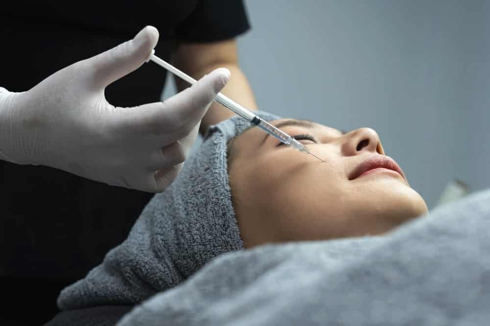 A trained injector applying nasolabial fold filler with precise technique.