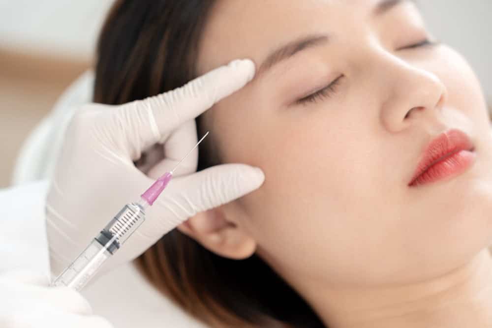 A patient receiving a precise Juvederm filler injection from a clinician.
