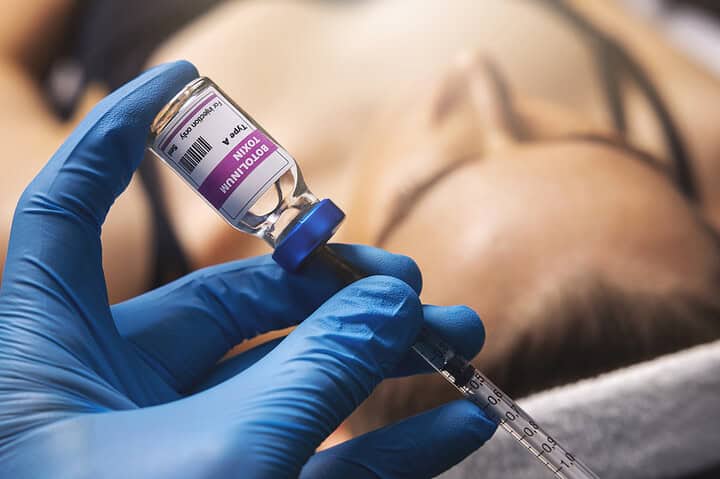 A close-up of an Allergan Botox vial held by a cosmetic doctor before a treatment session.