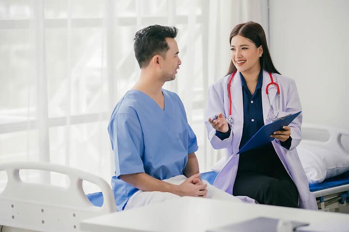 A transgender patient consulting with a plastic surgeon about FTM top surgery in Bangkok.