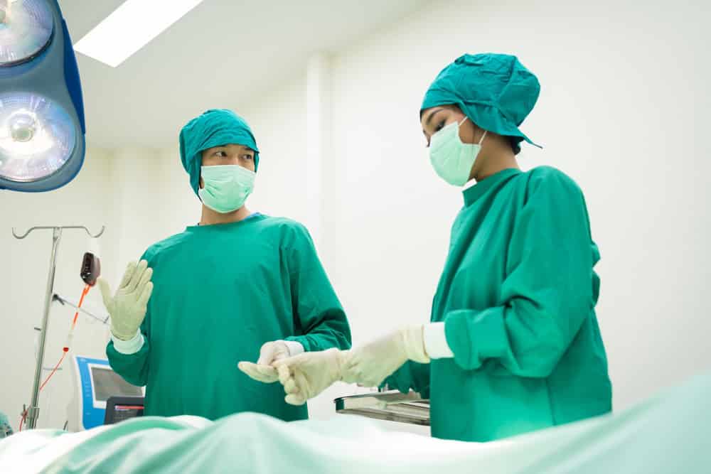 A team of surgeons in Thailand preparing to perform FTM top surgery for a patient.
